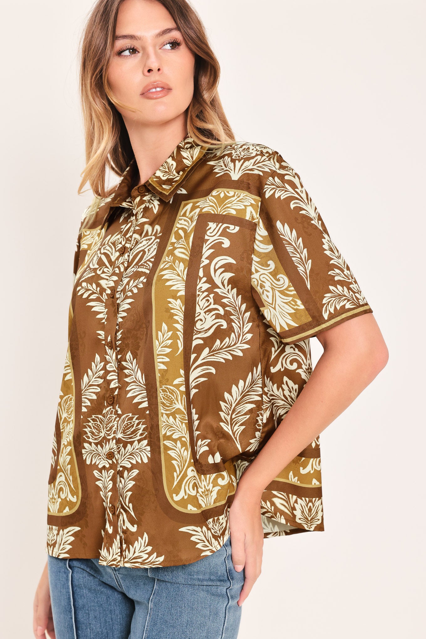 Woman wearing a brown floral patterned button down top | Flying Tomato
