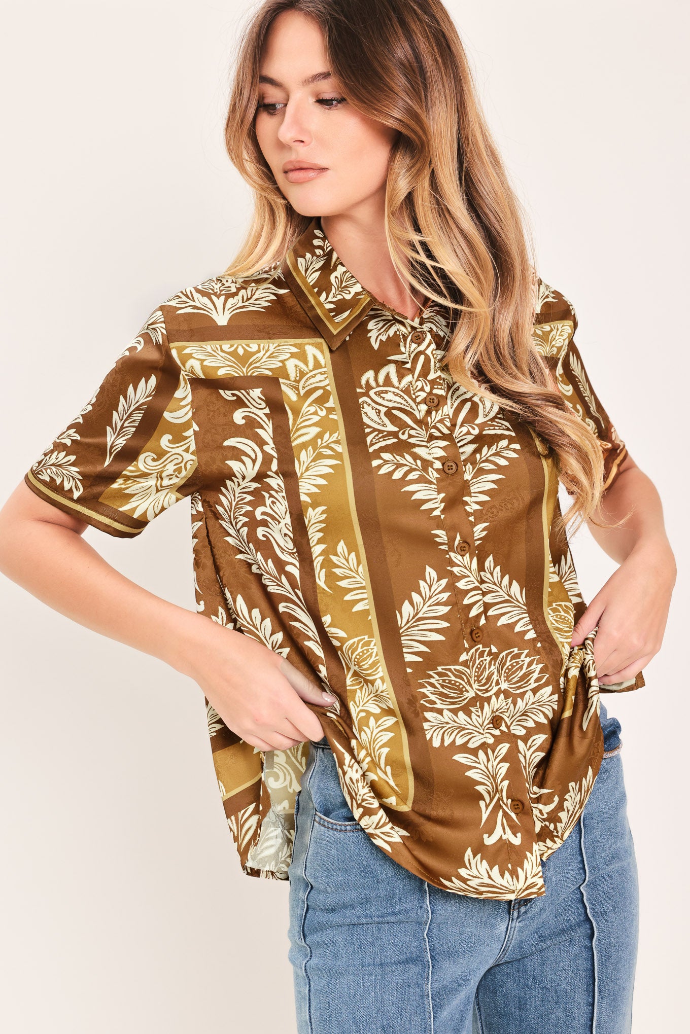 Woman wearing a brown floral patterned button down top | Flying Tomato