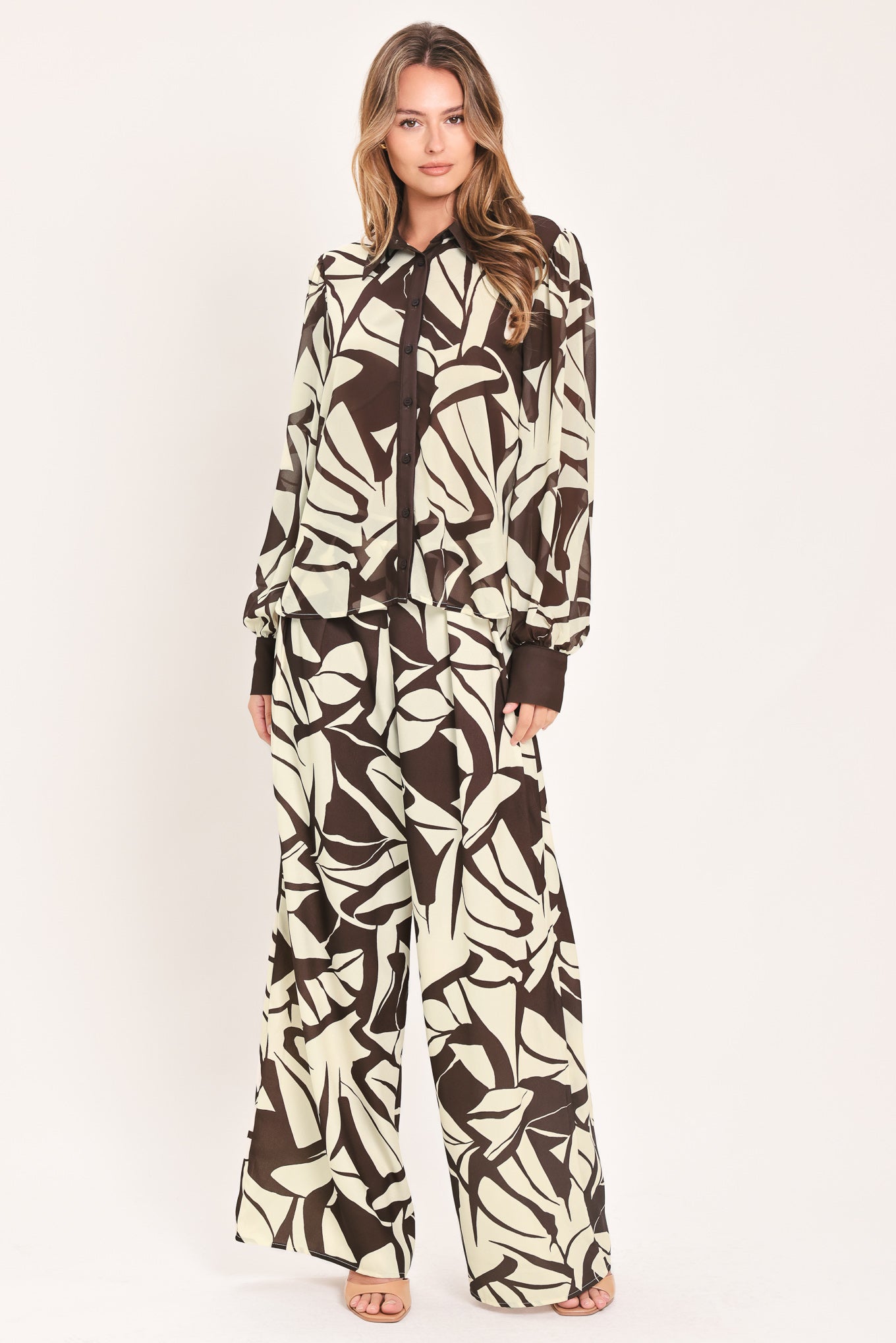 A woman wearing a long-sleeve button-up blouse with an abstract brown and cream pattern | Flying Tomato