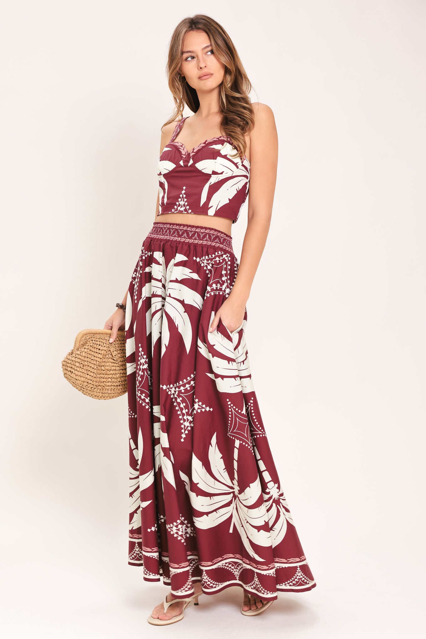 Woman wearing a red and white patterned top and skirt set with printed palm tree design | Flying Tomato