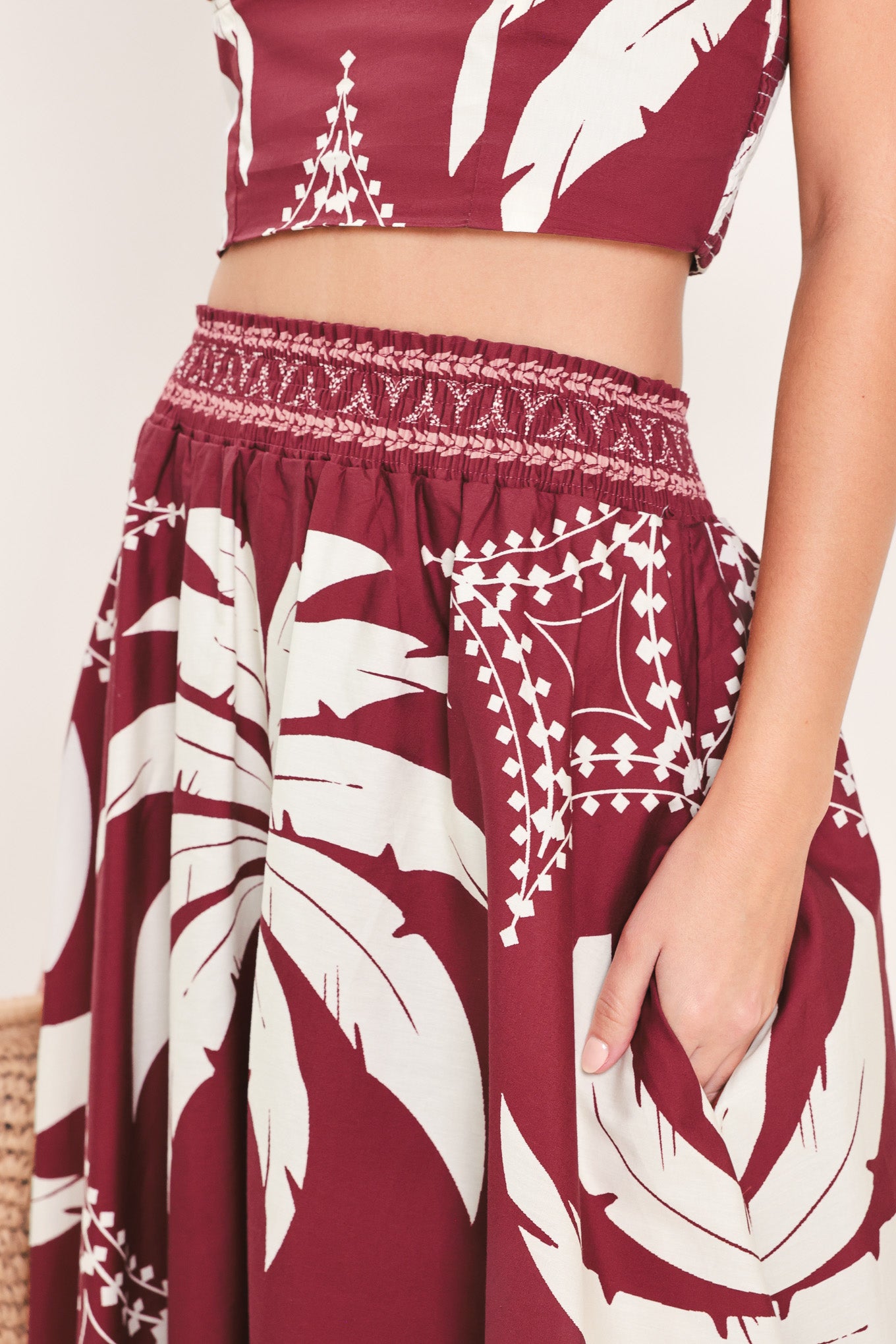Woman wearing a red and white patterned top and skirt set with printed palm tree design | Flying Tomato