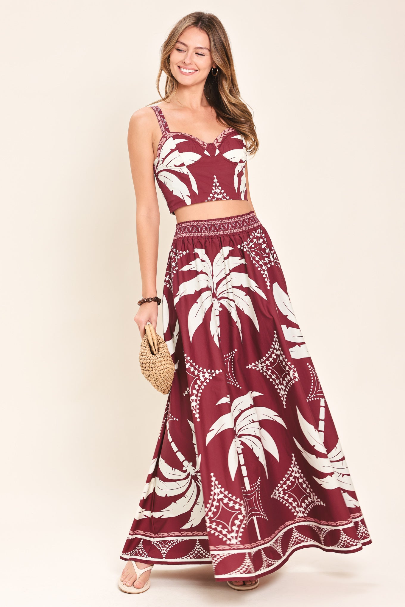 Woman wearing a red and white patterned top and skirt set with printed palm tree design | Flying Tomato