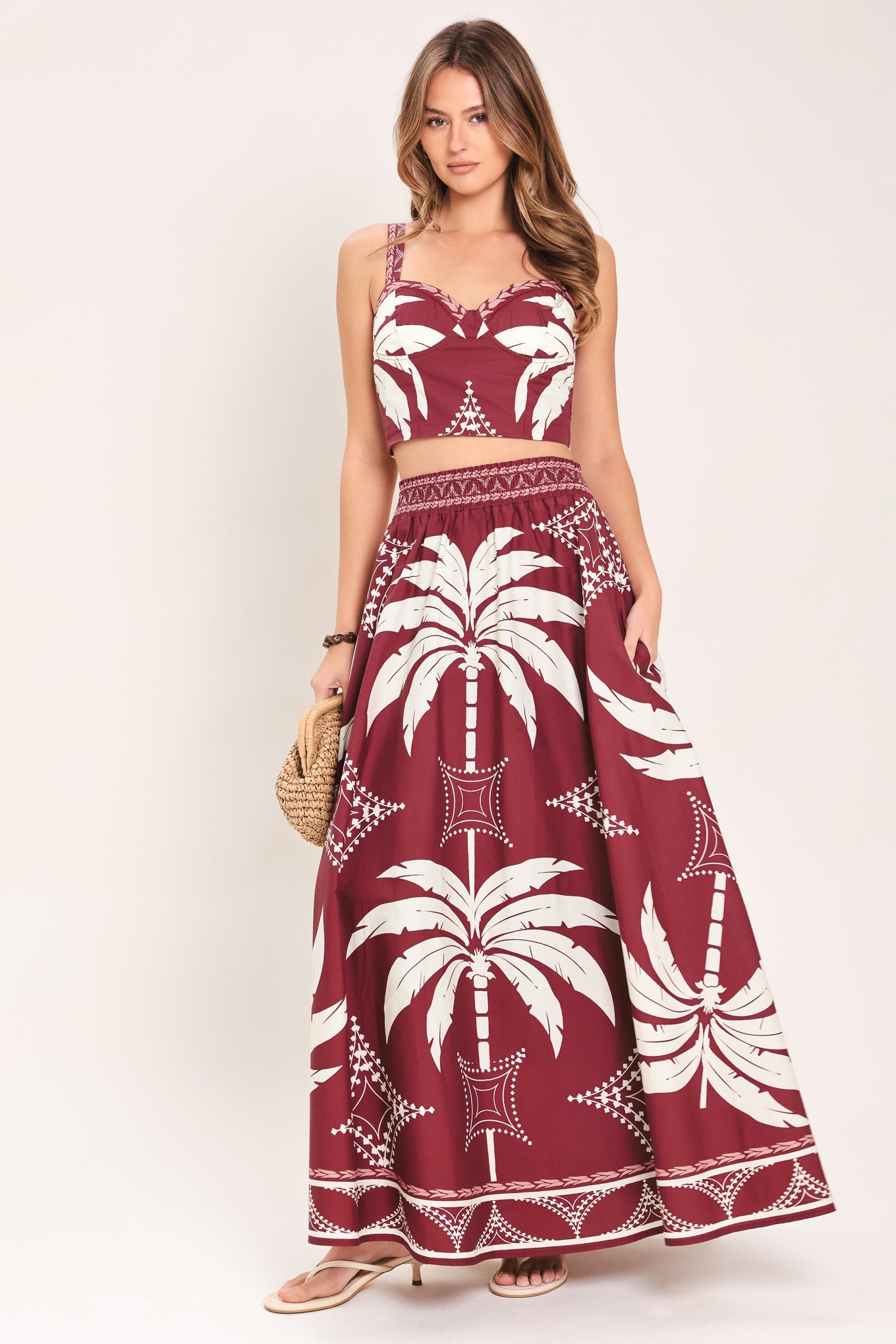 Woman wearing a red and white patterned top and skirt set with printed palm tree design | Flying Tomato