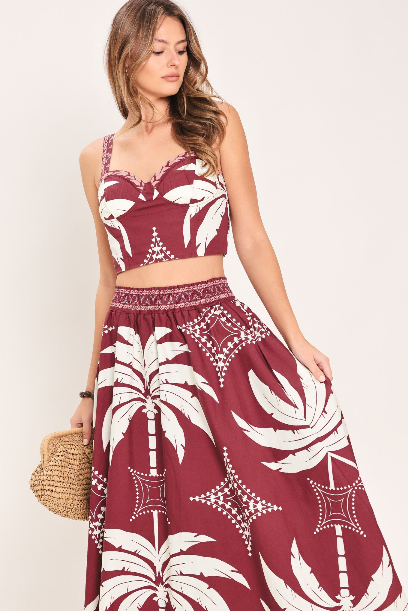 Woman wearing a red and white patterned top and skirt set with printed palm tree design | Flying Tomato
