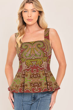 A woman wearing a sleeveless peplum top with a brown, olive green, and beige paisley pattern | Flying Tomato