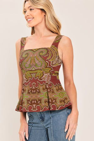 A woman wearing a sleeveless peplum top with a brown, olive green, and beige paisley pattern | Flying Tomato