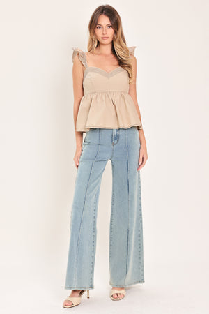 Woman wearing a beige top with ruffled sleeves featuring sweetheart neckline, peplum and smocked back bodice | Flying Tomato