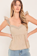 Woman wearing a beige top with ruffled sleeves featuring sweetheart neckline, peplum and smocked back bodice | Flying Tomato