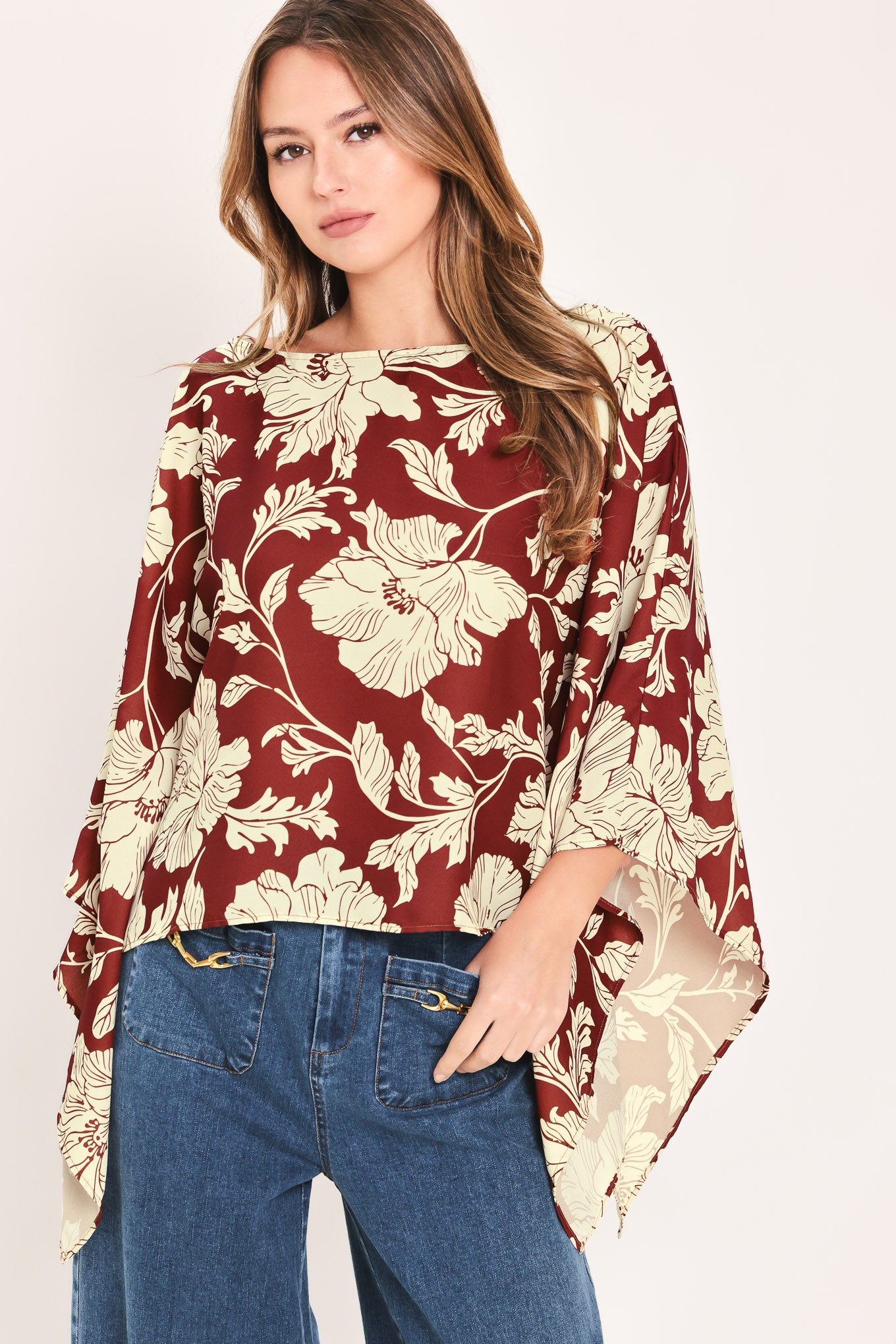 A woman wearing a burgundy and cream floral print top with wide bell sleeves | Flying Tomato