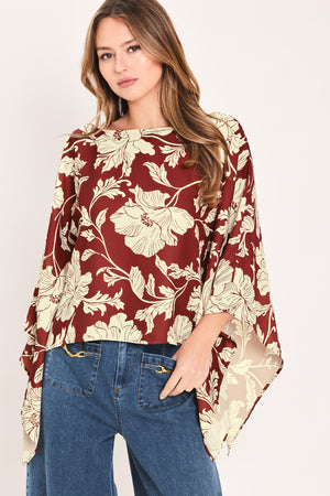 A woman wearing a burgundy and cream floral print top with wide bell sleeves | Flying Tomato