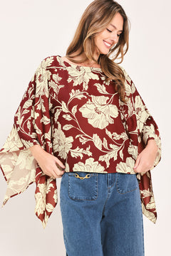 A woman wearing a burgundy and cream floral print top with wide bell sleeves | Flying Tomato