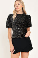 A woman modeling a black sequined short-sleeve top with puffed sleeves | Flying Tomato