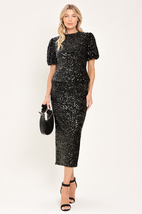 A woman modeling a black sequined short-sleeve top with puffed sleeves | Flying Tomato