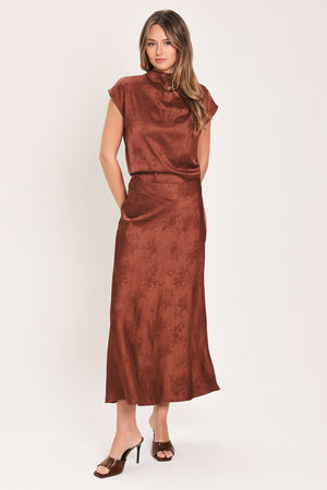 Woman wearing a cap sleeve burgundy satin jacquard top | Flying Tomato