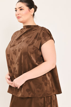 A woman modeling a brown short-sleeve top with a darker brown floral jacquard pattern, paired with a matching brown skirt | Plus Curve Flying Tomato