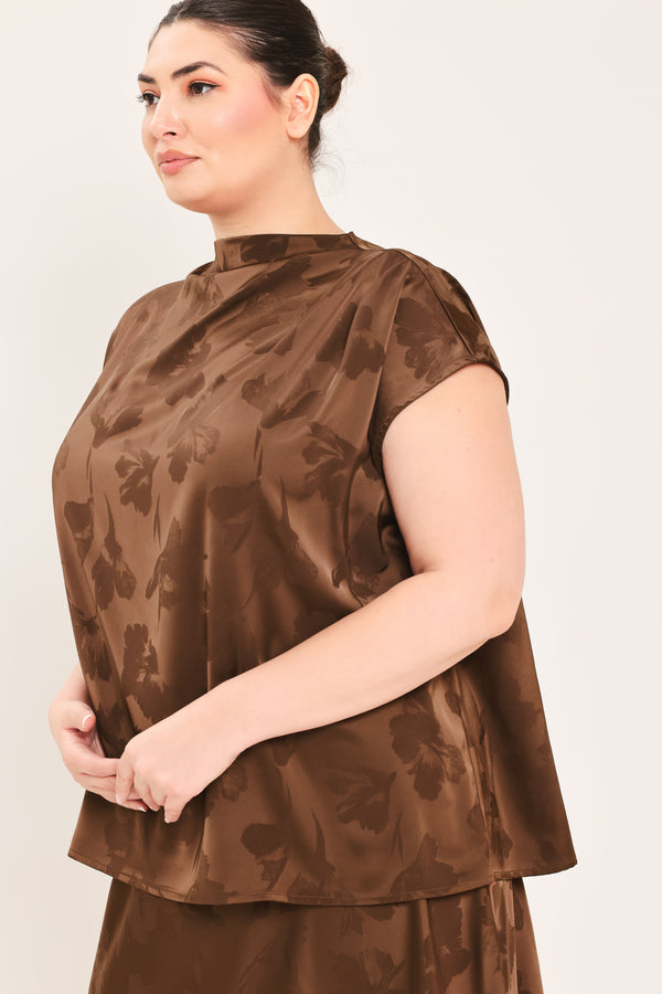 A woman modeling a brown short-sleeve top with a darker brown floral jacquard pattern, paired with a matching brown skirt | Plus Curve Flying Tomato