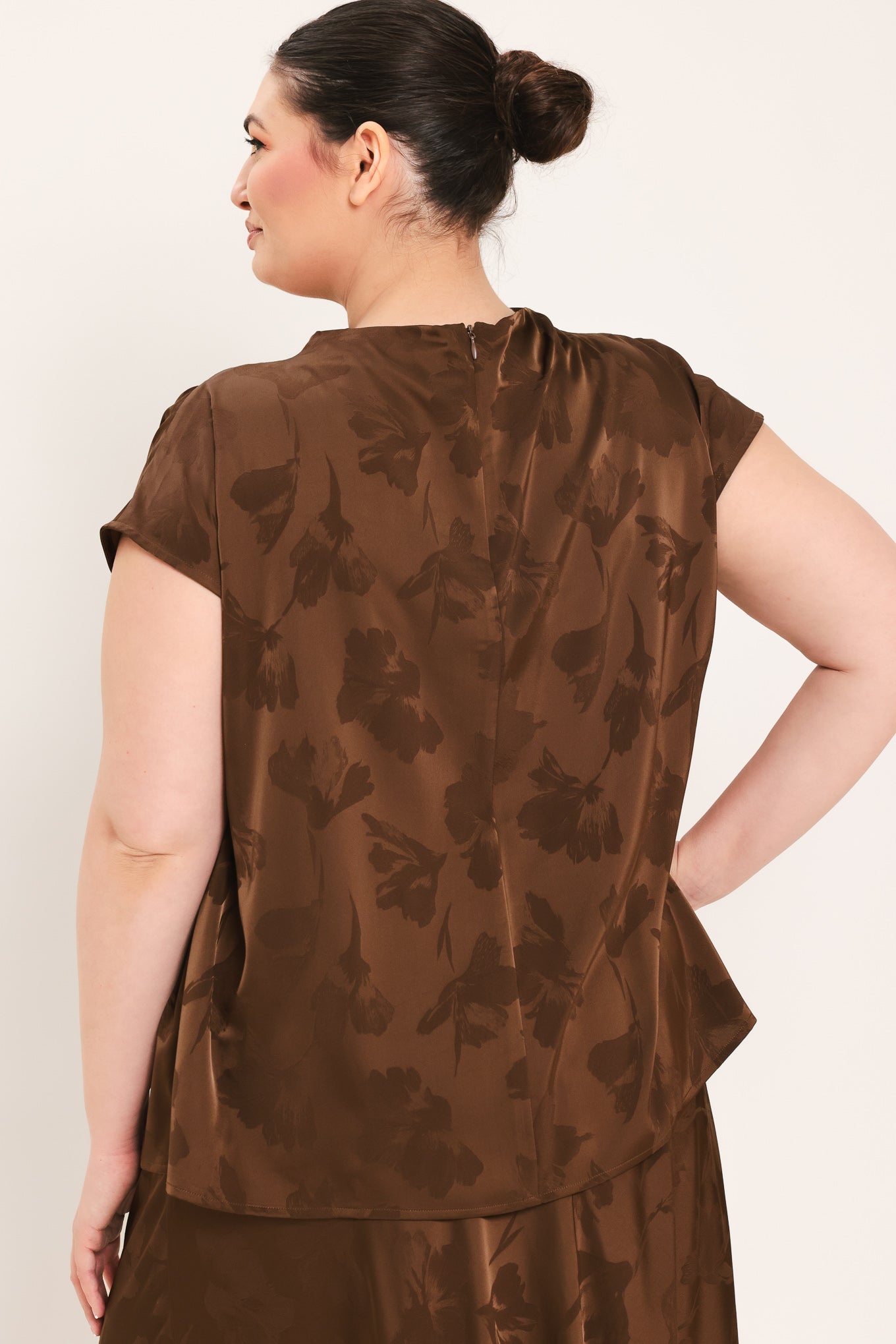 A woman modeling a brown short-sleeve top with a darker brown floral jacquard pattern, paired with a matching brown skirt | Plus Curve Flying Tomato