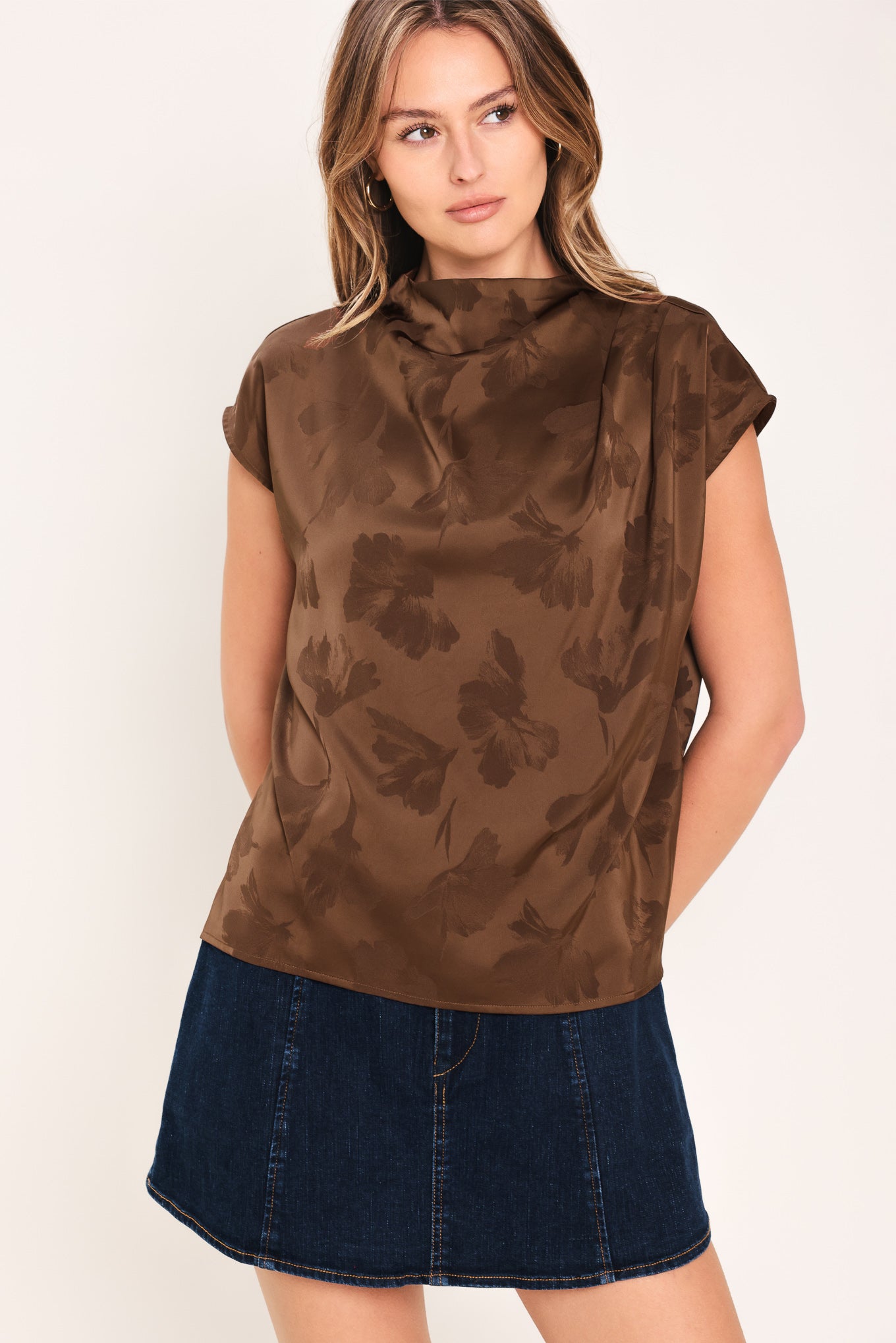 Woman wearing a brown jacquard top featuring funnel neckline, short sleeve and back zipper closure | Flying Tomato