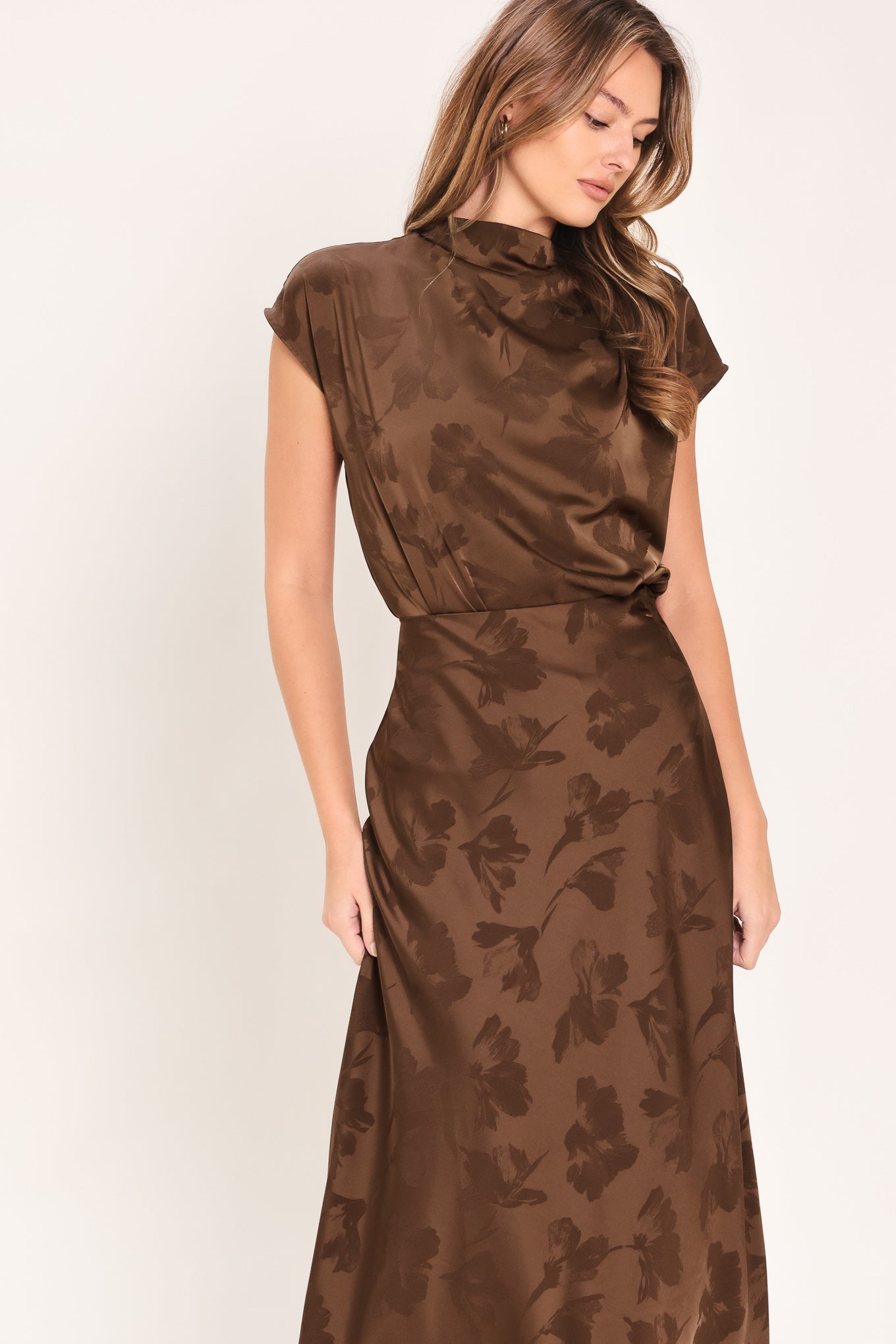 Woman wearing a brown jacquard top featuring funnel neckline, short sleeve and back zipper closure | Flying Tomato