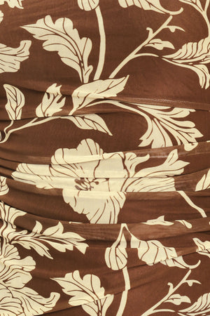 A woman wearing a brown halter-neck top with a beige floral print | Flying Tomato