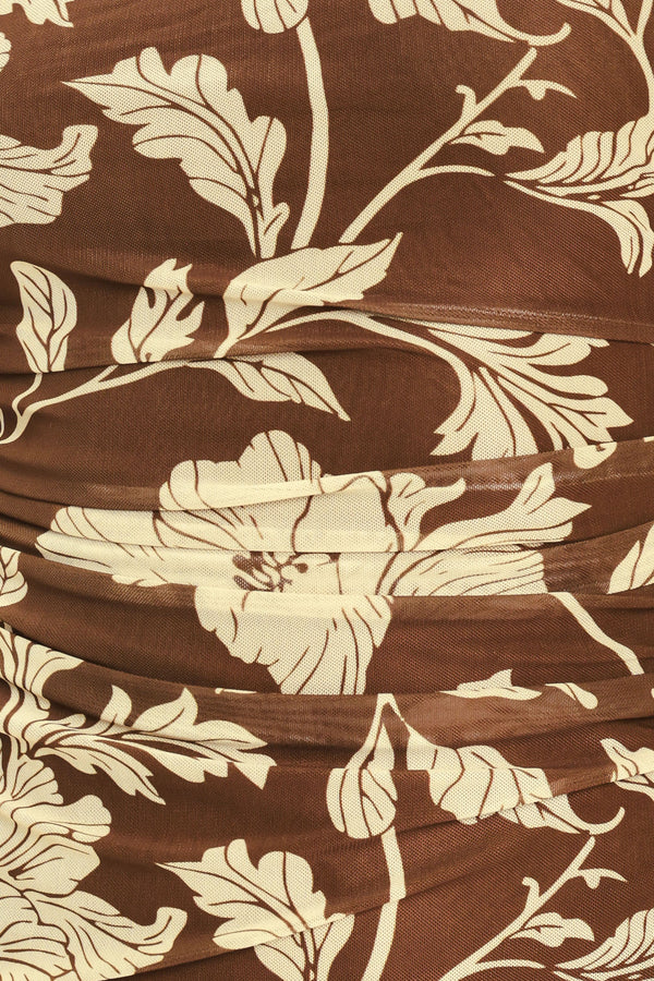 A woman wearing a brown halter-neck top with a beige floral print | Flying Tomato