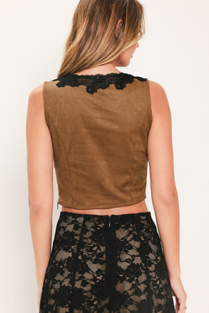 A woman wearing a faux suede brown sleeveless crop top with a black lace V-neck trim | Flying Tomato
