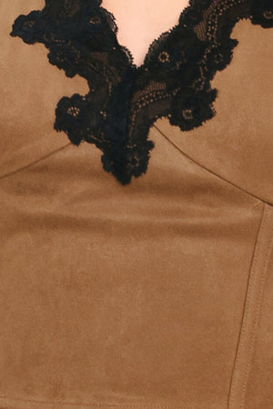 A woman wearing a faux suede brown sleeveless crop top with a black lace V-neck trim | Flying Tomato