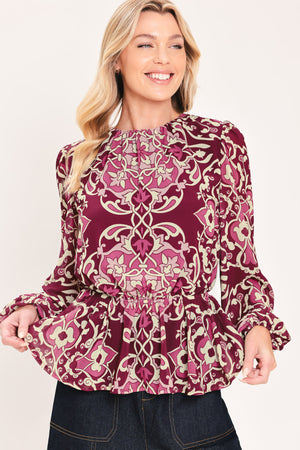 A woman modeling a long-sleeve peplum blouse with a burgundy and beige baroque-style pattern | Flying Tomato
