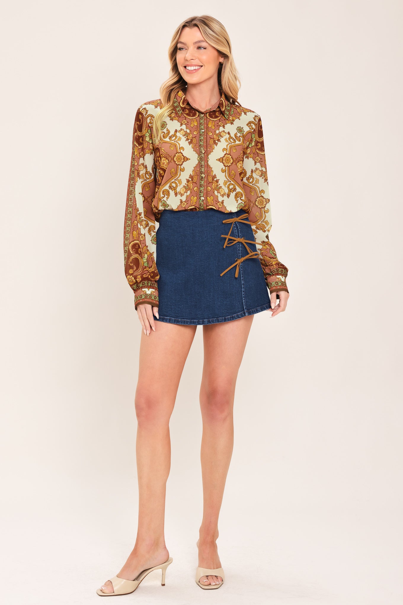 A woman wearing a long-sleeve button-up blouse with an ornate paisley and floral pattern in brown, gold, and cream | Flying Tomato