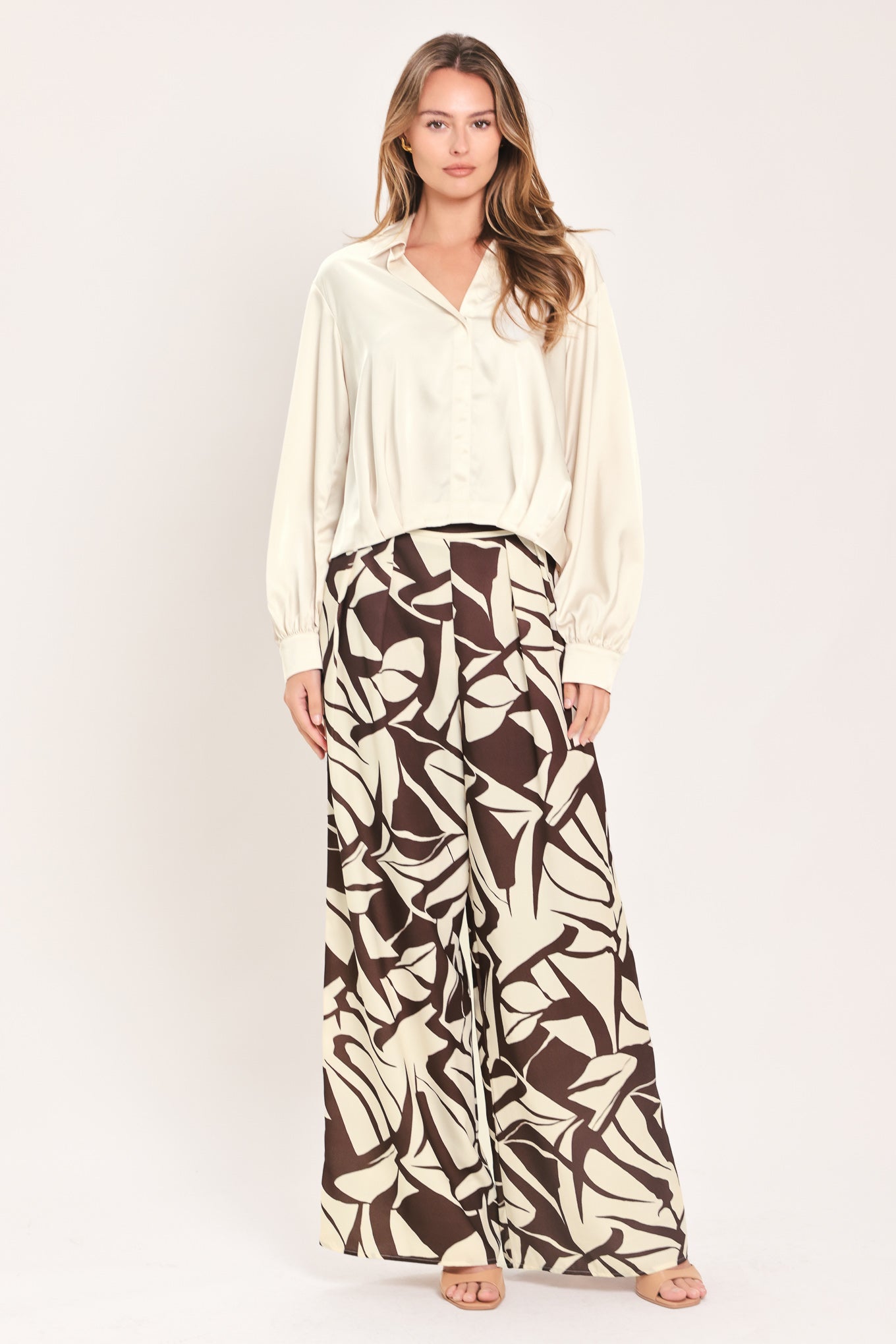 A woman wearing a champagne-colored satin long-sleeve blouse with a button-down front | Flying Tomato