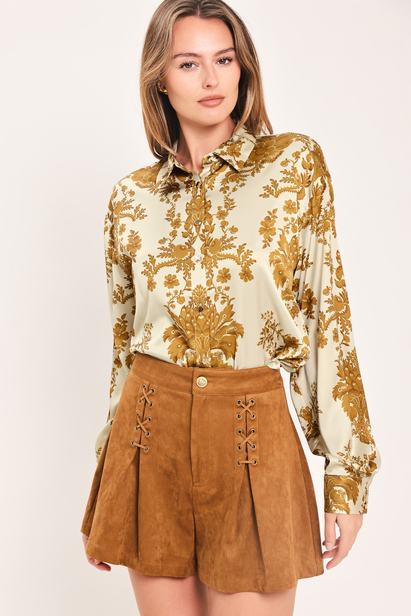 A woman wearing a long-sleeve button-up blouse with a beige and gold damask pattern | Flying Tomato