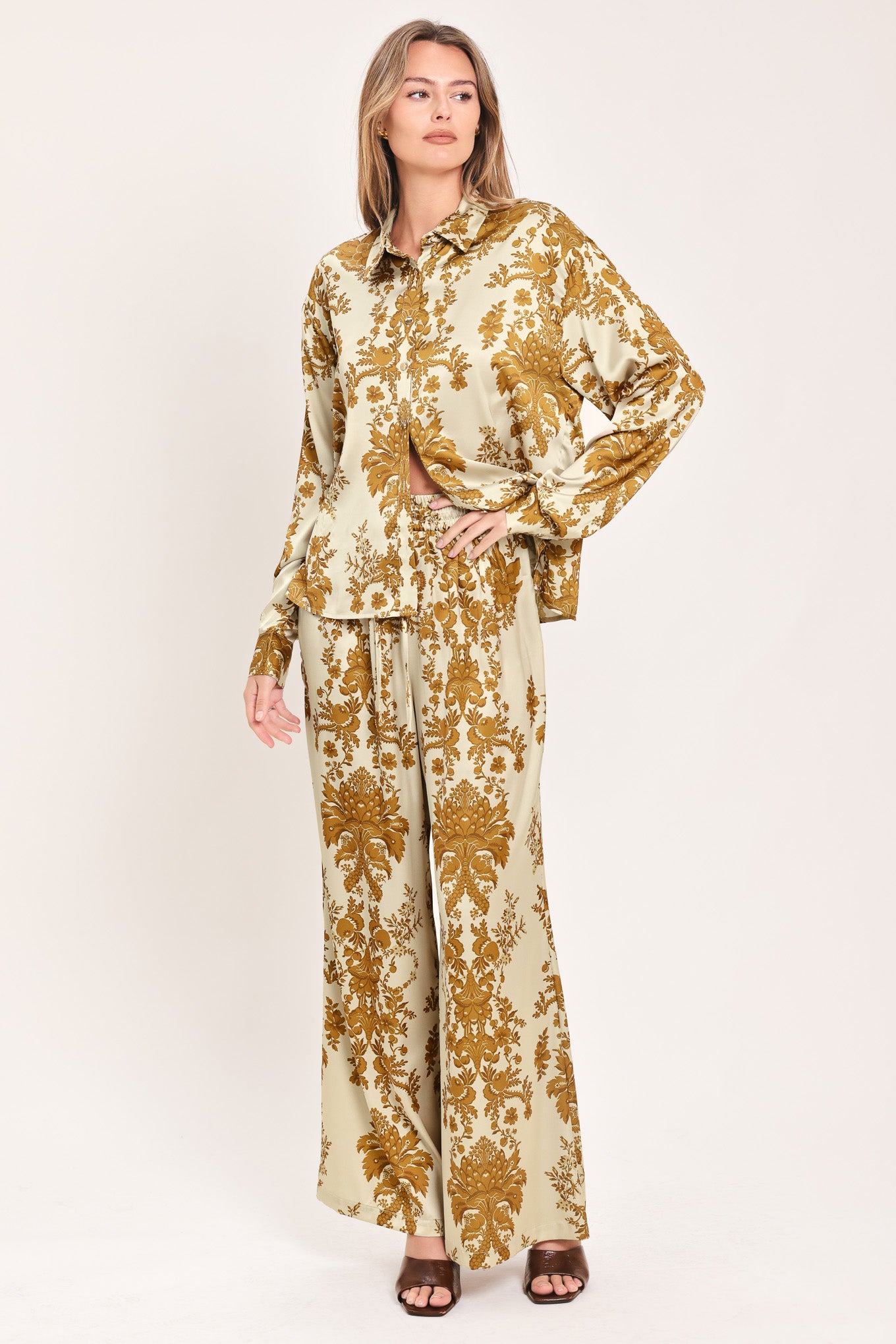A woman wearing a long-sleeve button-up blouse with a beige and gold damask pattern | Flying Tomato