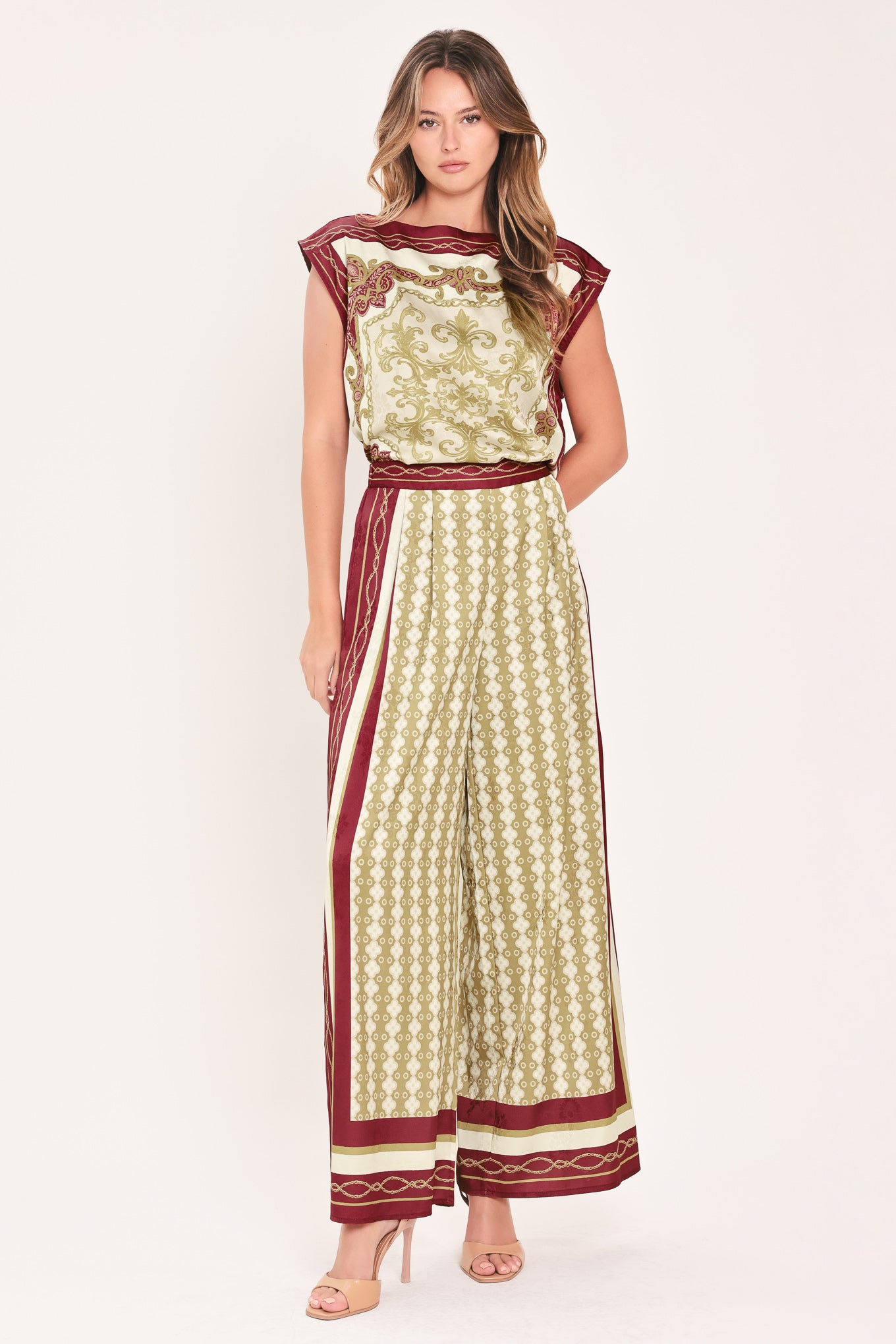 A woman wearing a sleeveless top with a cream base and ornate burgundy and olive-gold baroque-style border and damask pattern | Flying Tomato