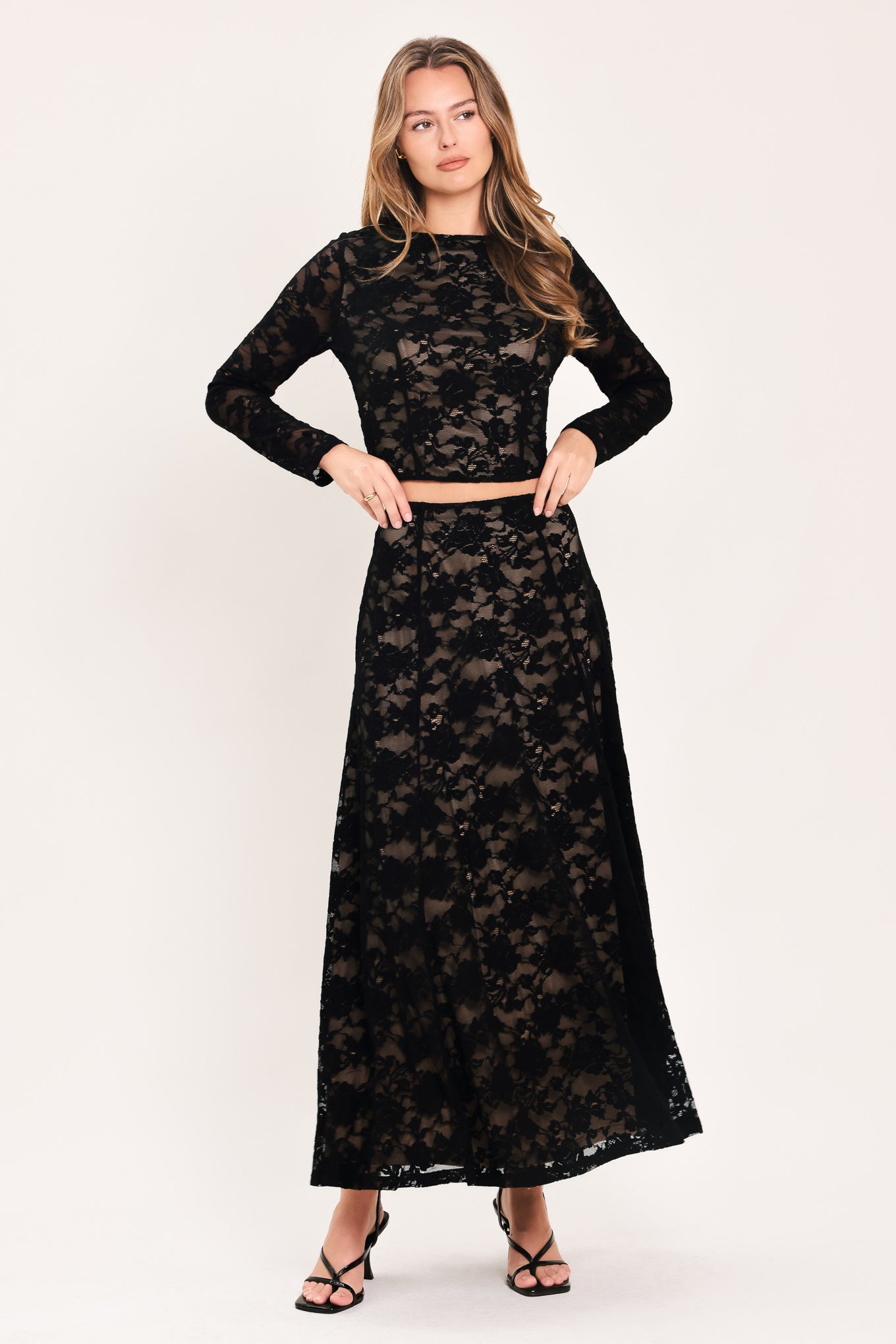 A woman wearing a black long-sleeve lace crop top  | Flying Tomato