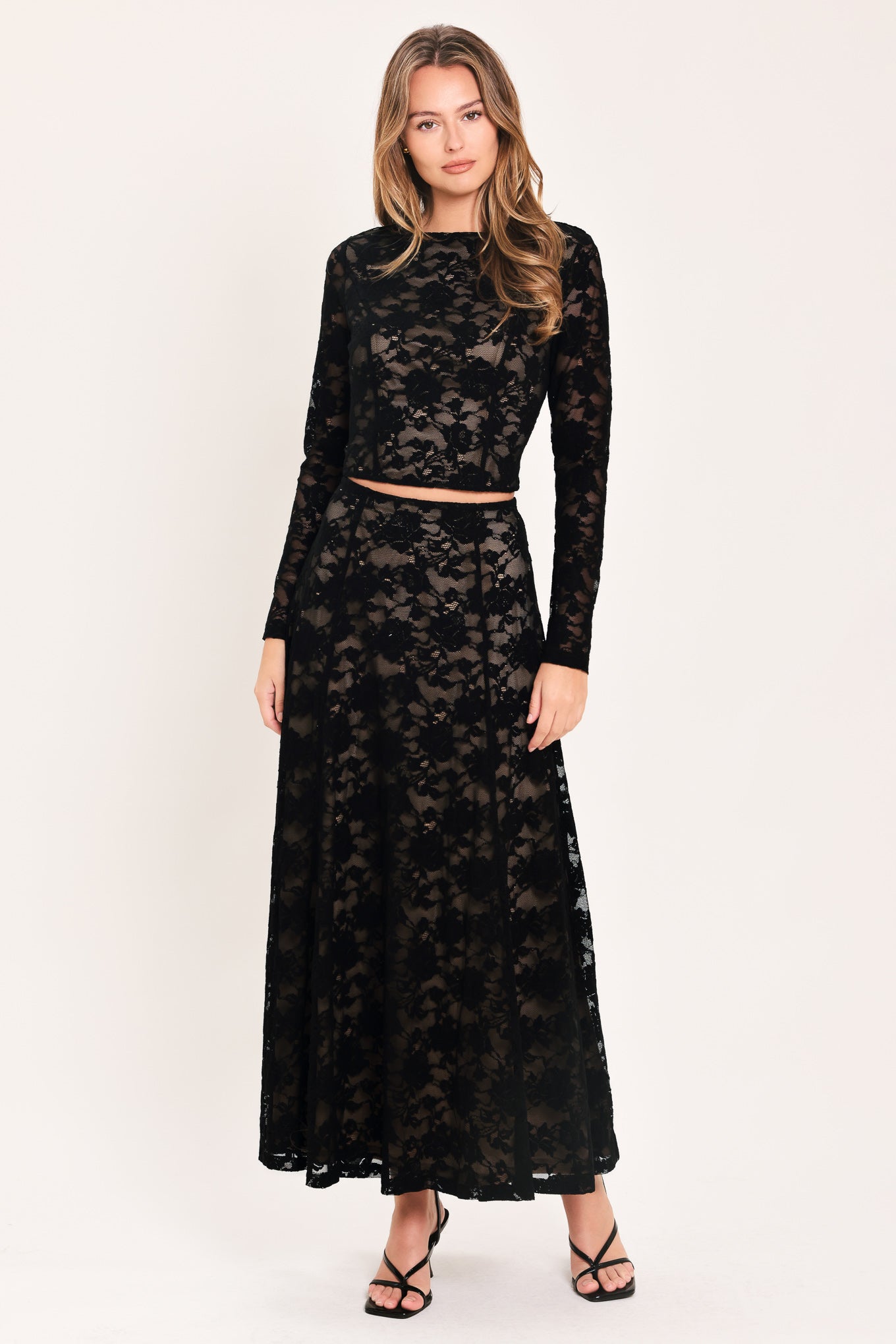 A woman wearing a black long-sleeve lace crop top  | Flying Tomato