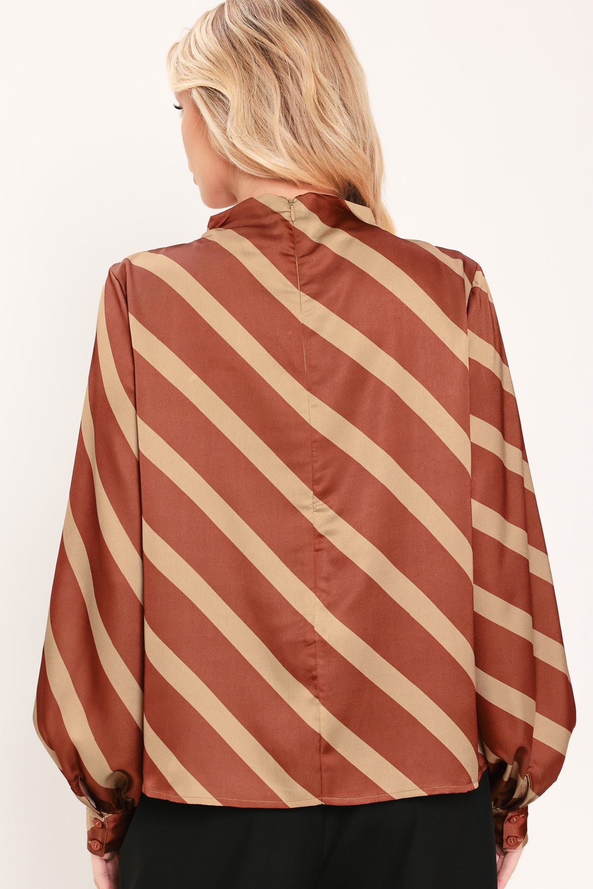 A woman wearing a brown and beige diagonally striped satin blouse with long balloon sleeves | Flying Tomato