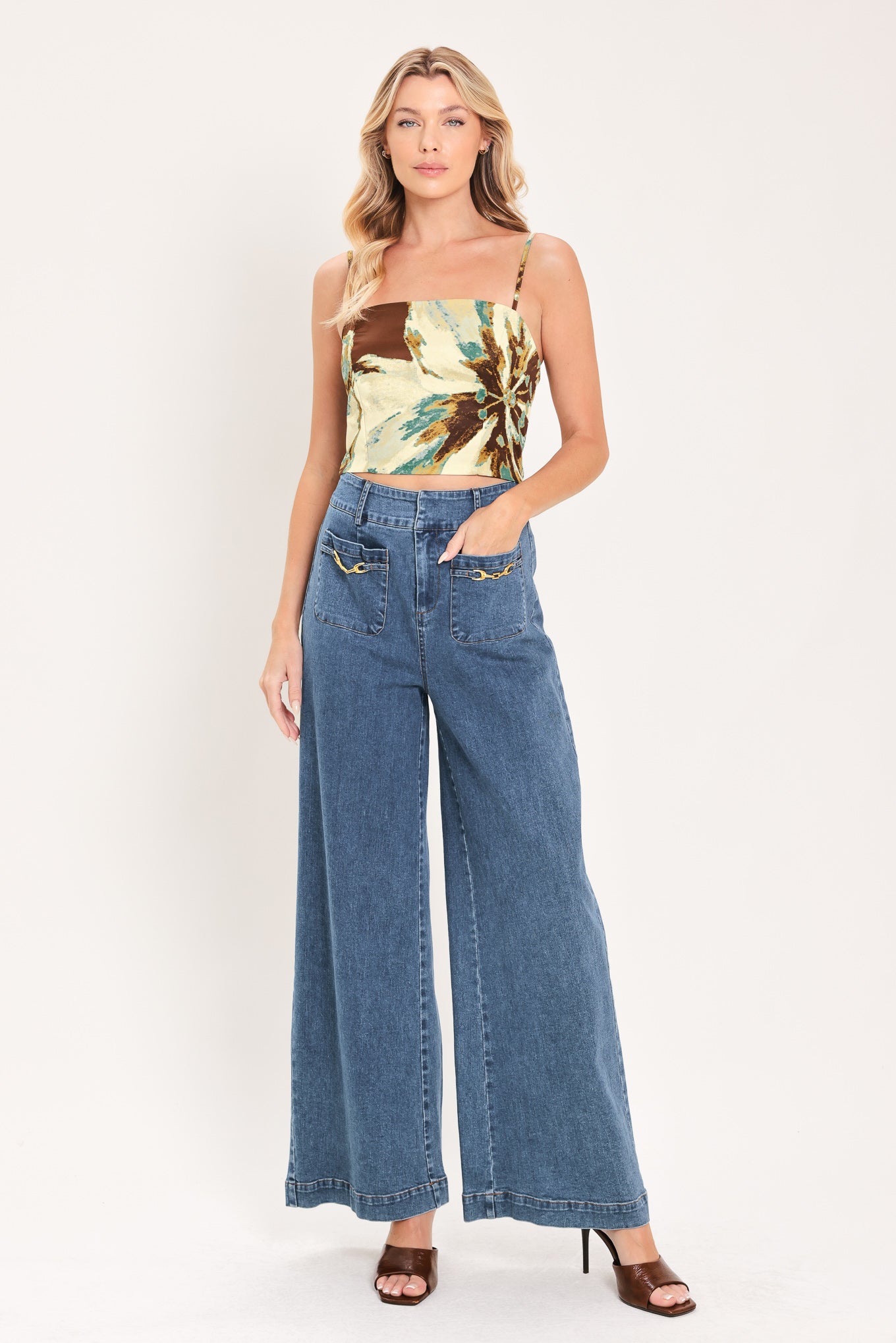 A woman modeling a sleeveless top and  matching maxi skirt with a brown and cream floral print and teal accents | Flying Tomato