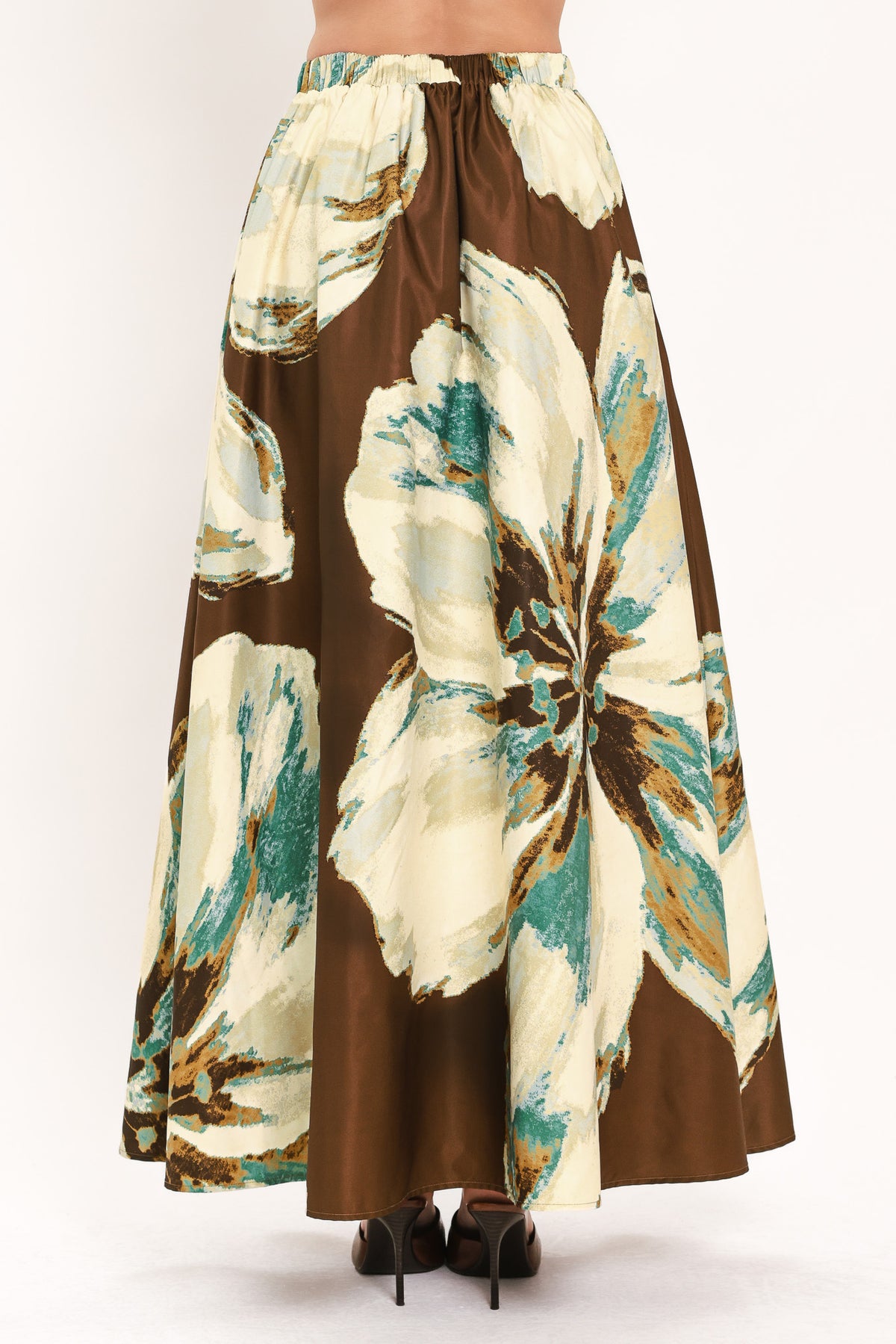 A woman modeling a sleeveless top and  matching maxi skirt with a brown and cream floral print and teal accents | Flying Tomato