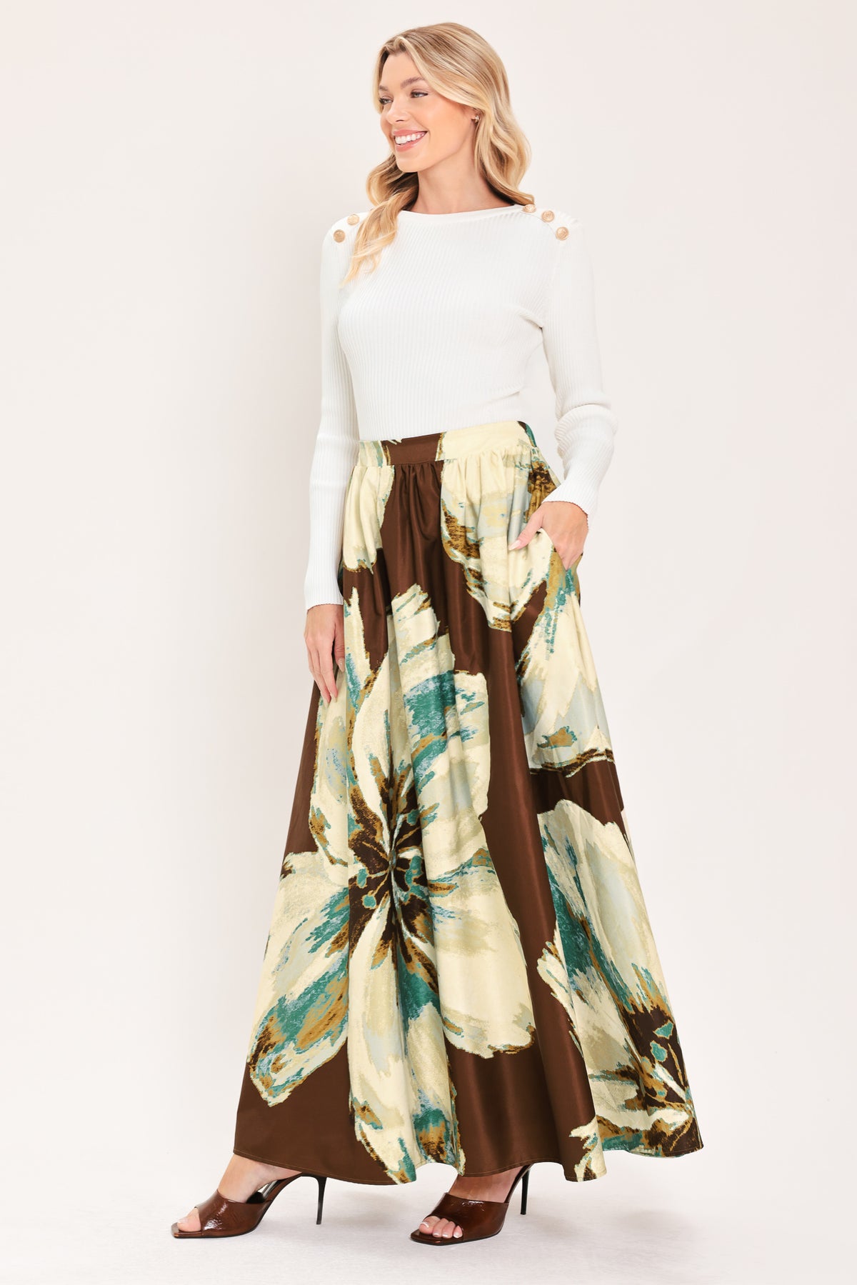A woman modeling a sleeveless top and  matching maxi skirt with a brown and cream floral print and teal accents | Flying Tomato