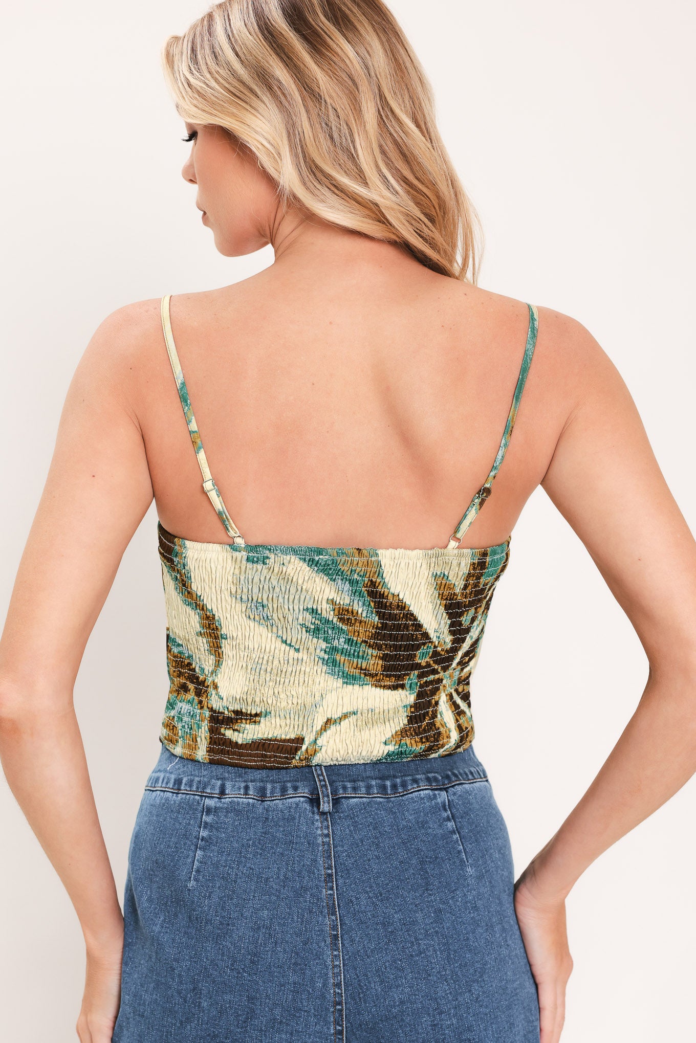 A woman modeling a sleeveless top and  matching maxi skirt with a brown and cream floral print and teal accents | Flying Tomato