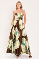 A woman modeling a sleeveless top and  matching maxi skirt with a brown and cream floral print and teal accents | Flying Tomato