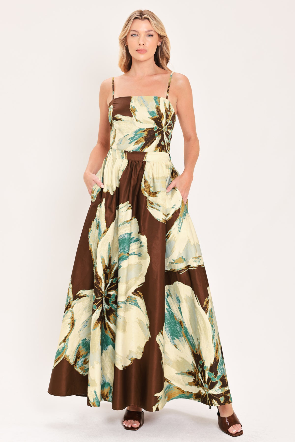 A woman modeling a sleeveless top and  matching maxi skirt with a brown and cream floral print and teal accents | Flying Tomato