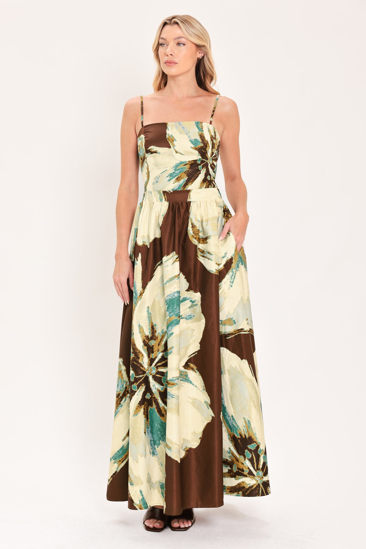 A woman modeling a sleeveless top and  matching maxi skirt with a brown and cream floral print and teal accents | Flying Tomato