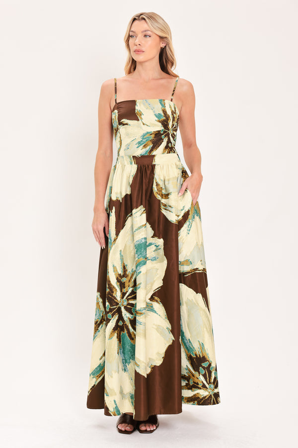 A woman modeling a sleeveless top and  matching maxi skirt with a brown and cream floral print and teal accents | Flying Tomato