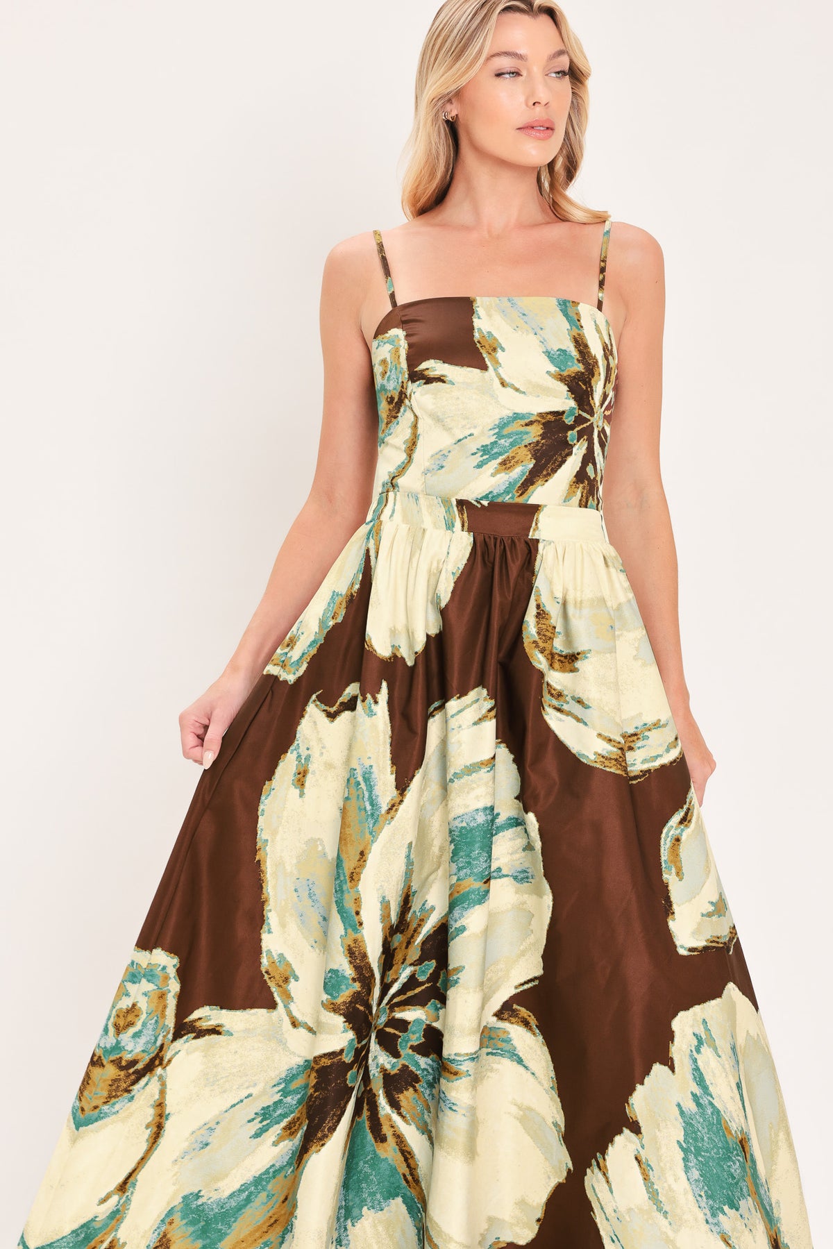 A woman modeling a sleeveless top and  matching maxi skirt with a brown and cream floral print and teal accents | Flying Tomato