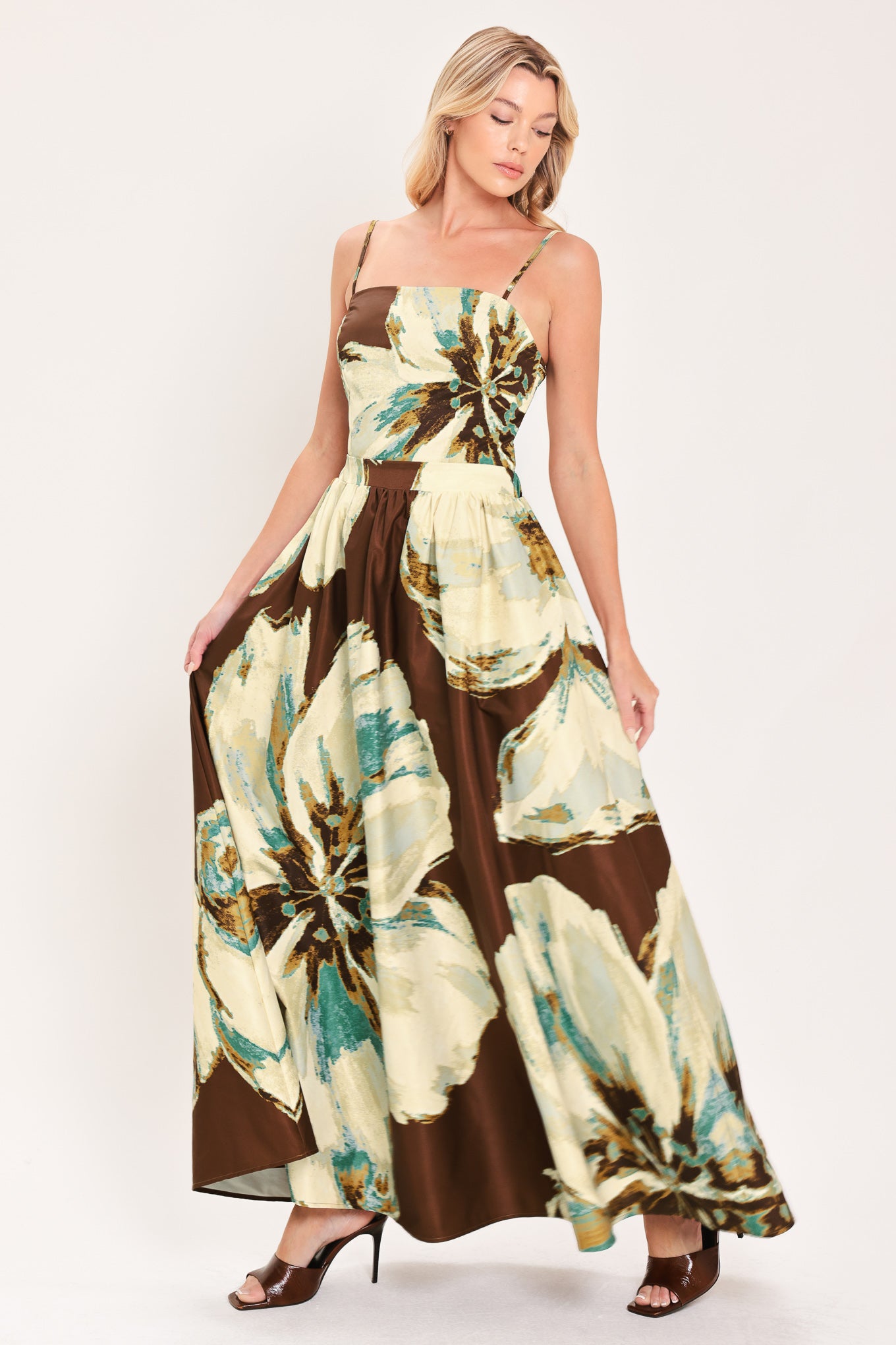 A woman modeling a sleeveless top and  matching maxi skirt with a brown and cream floral print and teal accents | Flying Tomato