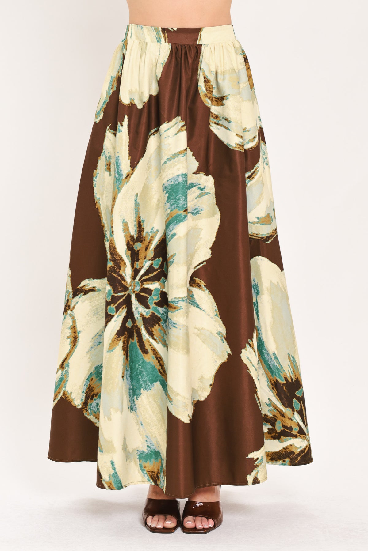 A woman modeling a sleeveless top and  matching maxi skirt with a brown and cream floral print and teal accents | Flying Tomato