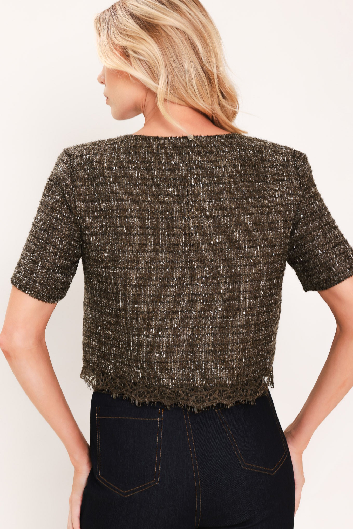 A woman wearing a short-sleeve textured tweed top in dark dark khaki with subtle silver flecks | Flying Tomato
