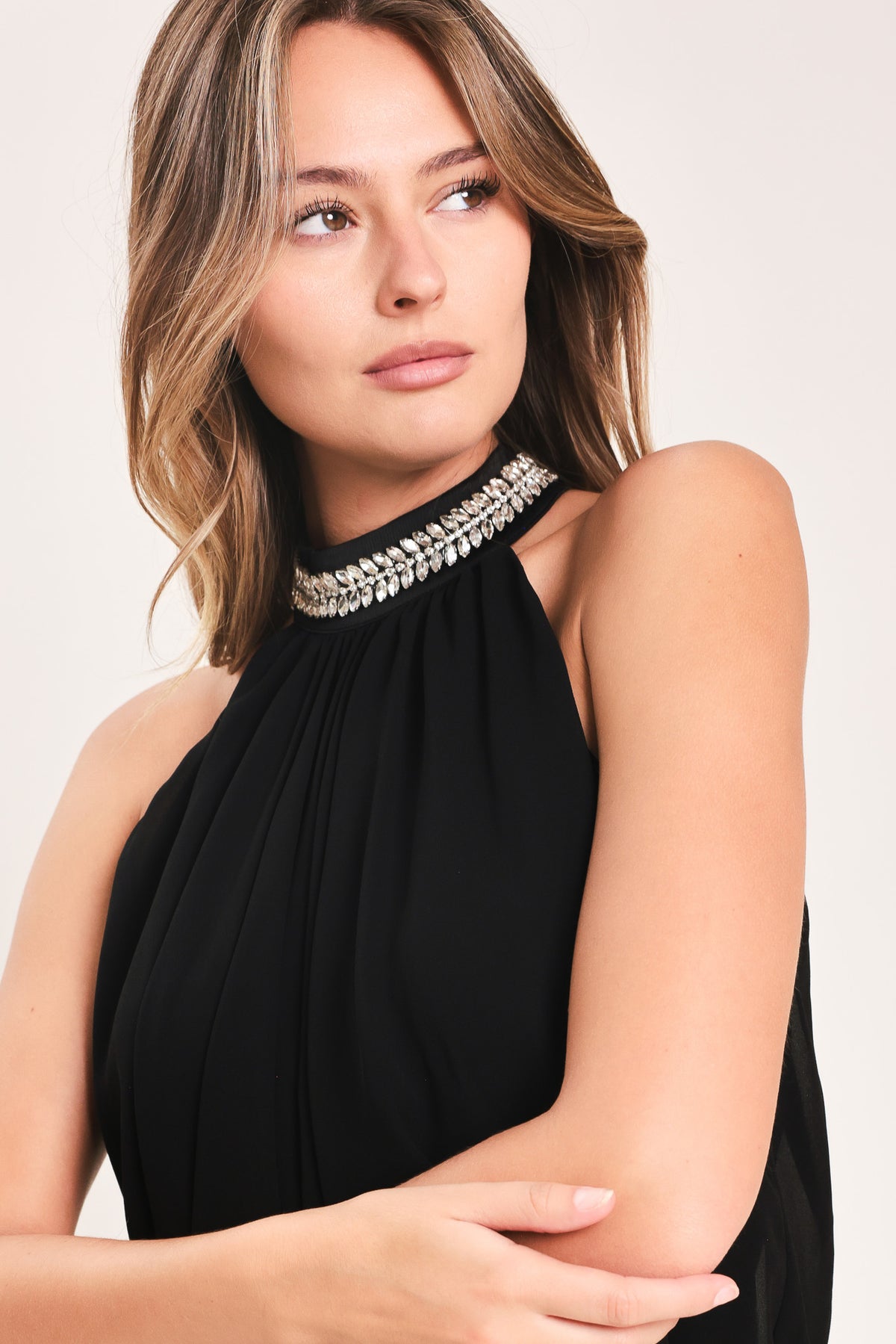 A woman modeling a sleeveless black halter top and wide leg pant set with a beaded choker neckline | Flying Tomato
