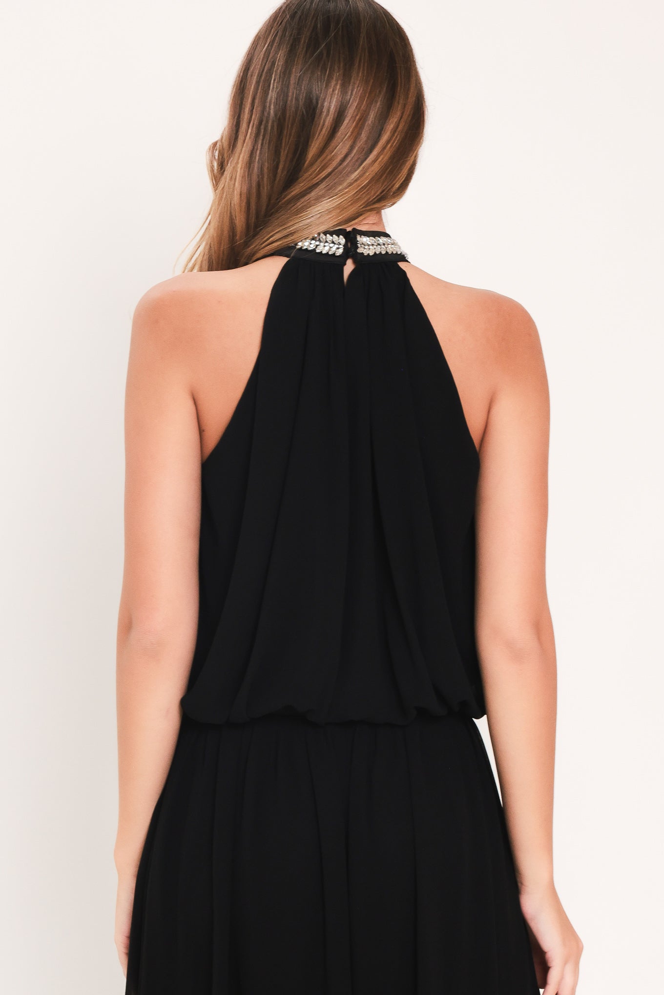 A woman modeling a sleeveless black halter top and wide leg pant set with a beaded choker neckline | Flying Tomato